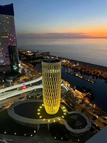 a view of a tall building at night at Alliance Palace in Marriott in Batumi