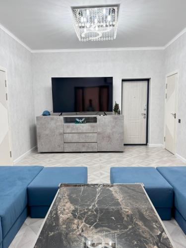 a living room with a blue couch and a table at Mountain paradise Премиум дача в Чимгане in Chimgan