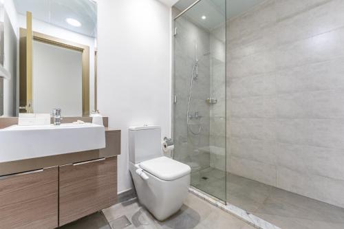 a bathroom with a toilet and a sink and a shower at HAVN - 2 Bedroom Apartment in Bloom Tower, JVC in Dubai