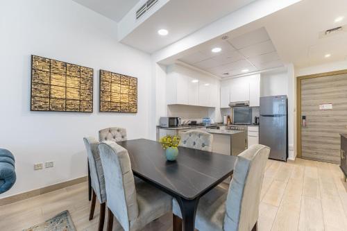 a dining room with a black table and chairs at HAVN - 2 Bedroom Apartment in Bloom Tower, JVC in Dubai