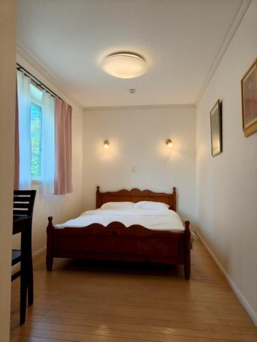 a bedroom with a bed and a window at izu花縁 in Ito