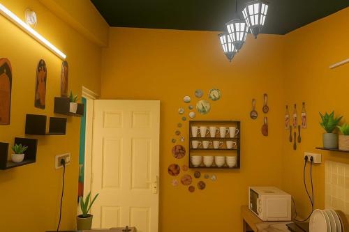 a kitchen with yellow walls and a white door at Candolim Beach, Pool view ,1bhk in Aguada