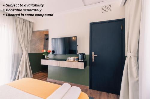 a room with a black door and a tv at Silverbeck Residence, Nanyuki in Nanyuki