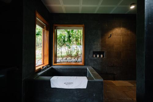 ハザンにあるAn Châng Retreat & Spaの窓付きのバスタブを備えた黒いバスルーム