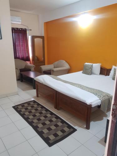 a bedroom with a bed and a couch and a chair at Hotel Arham Inn in Rānchī