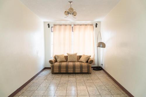 a living room with a couch in front of a window at Casa-Alojamiento Tierra Roja zona centro in Arandas