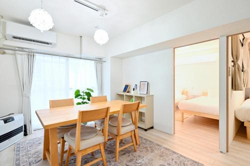 a dining room with a table and chairs and a bedroom at シャトーひらぎし in Sapporo