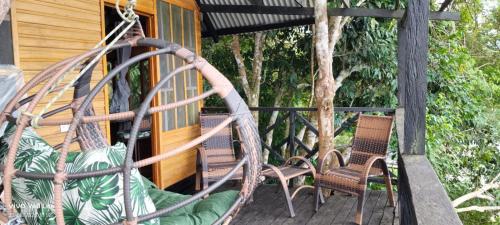a porch with two chairs and a swing at Eware Treehouse in Puerto Nariño