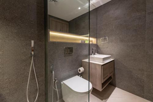 a bathroom with a toilet and a sink and a shower at HAVN - Studio Apartment in Pantheon Elysee, JVC in Dubai