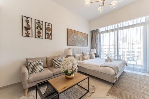 a living room with a couch and a table at HAVN - Studio Apartment in Pantheon Elysee, JVC in Dubai