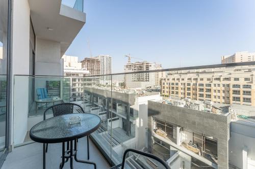 a balcony with a table and a view of a city at HAVN - Studio Apartment in Pantheon Elysee, JVC in Dubai