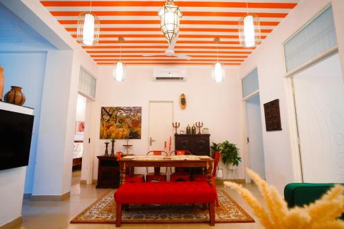 a dining room with an orange and white striped ceiling at Aurora Luxe Residence in Jaipur