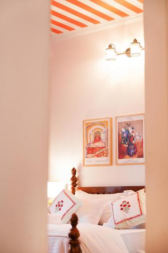 a bedroom with a bed with two pictures on the wall at Aurora Luxe Residence in Jaipur