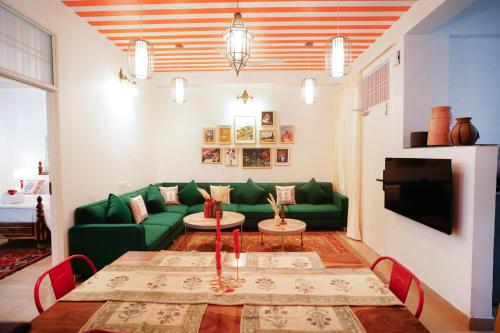 a living room with a green couch and a table at Aurora Luxe Residence in Jaipur