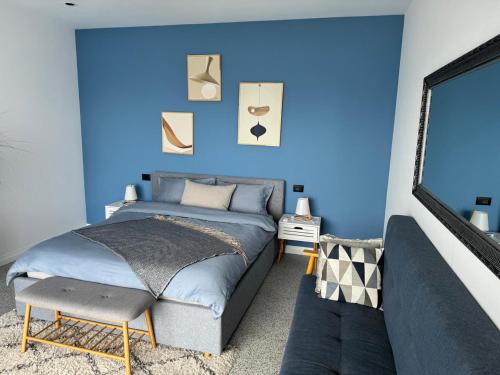 a blue bedroom with a bed and a chair at Lake Breeze Villa with a Pool & Magnificent Views in Široka