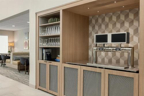 a lobby with a bar with a tv on a wall at Homewood Suites by Hilton Denver West - Lakewood in Lakewood