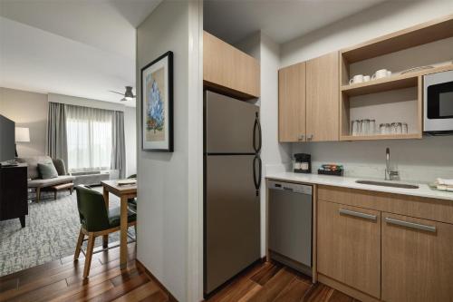 a kitchen with a refrigerator and a dining room at Homewood Suites by Hilton Denver West - Lakewood in Lakewood
