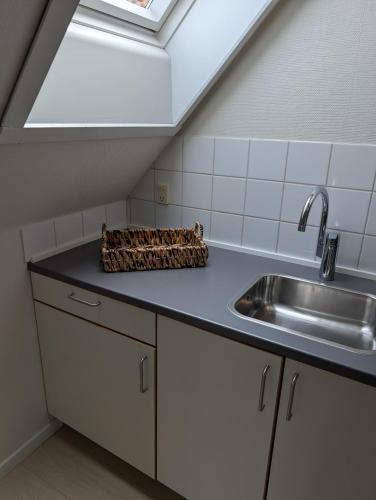 a kitchen with a sink and a skylight at Villa Koch X Pension Koch in Gudhjem