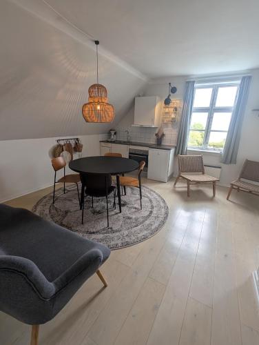 a living room with a table and chairs and a kitchen at Villa Koch X Pension Koch in Gudhjem