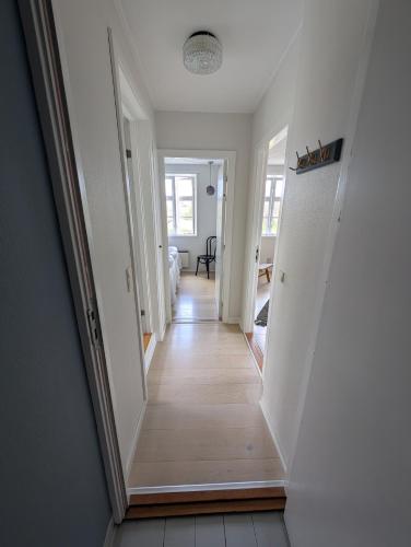 a hallway of a home with white walls and wooden floors at Villa Koch X Pension Koch in Gudhjem