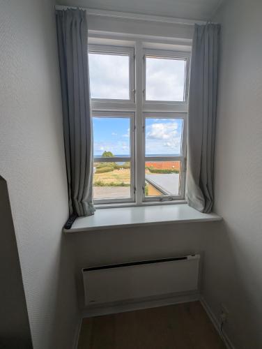 a window in a room with a view of a field at Villa Koch X Pension Koch in Gudhjem