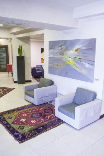 a living room with two chairs and a painting on the wall at Hotel Europa in Reggio Emilia
