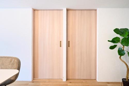 two doors in a room with a plant at シャトーひらぎし in Sapporo