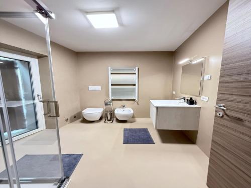 a bathroom with two toilets and a sink and a shower at Gomes Comfort House SUITE in Valeggio sul Mincio