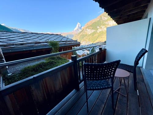 a balcony with a chair and a table and a view at Alpenlodge in Zermatt