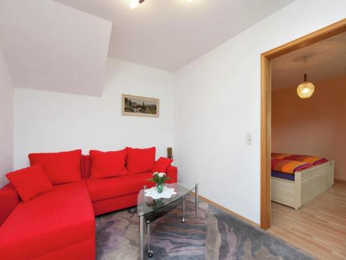a living room with a red couch and a bed at Müllenborn Mountain Nest in Gerolstein