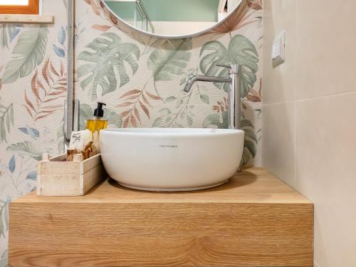 a bathroom with a white bowl sink on a wooden counter at Hotel Donatella in Posada