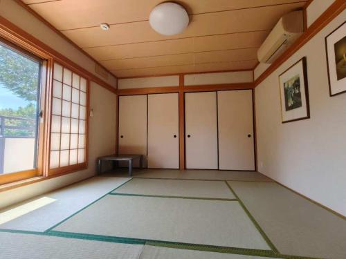 an empty room with a large window and a table at izu花縁 in Ito