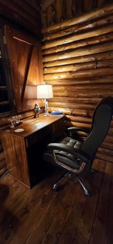 a desk with a chair in a room with wooden walls at Cabaña English Evergreen in Jardín