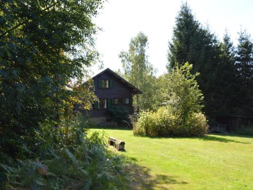una cabaña de madera en medio de un campo de césped en Chalet in Bièvre for 9 Person, en Bièvre