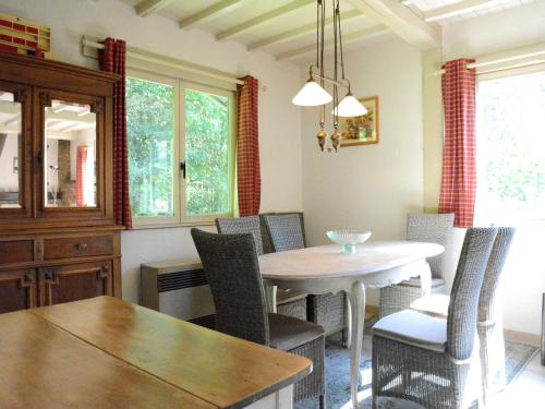 Un comedor con mesa y sillas en Chalet in Bièvre for 9 Person, en Bièvre