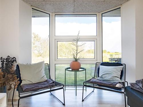 two chairs and a table in a room with windows at Luxury Retreat with Pool - By Traum Ferienwohnungen in Ho