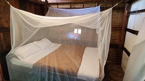 a bed with a mosquito net in a room at Le Soleil Kep - Surya Kep in Kep