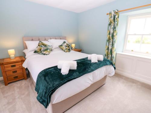 a bedroom with a large bed with towels on it at Peace Cottage in Darlington