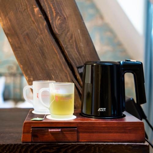two cups of coffee sitting on a wooden table at Romantik Hotel Barbarossa in Konstanz