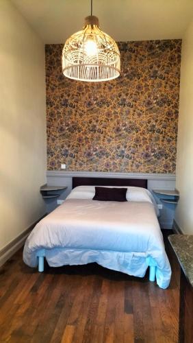 a bedroom with a large bed and a wall at aux petits soins in Oloron-Sainte-Marie