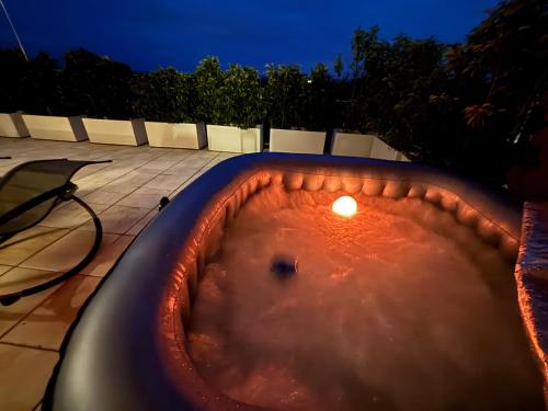 a bath tub with a candle in it at night at Penthouse mit Whirlpool, Traumblick und großer Dachterrasse in Bad Salzuflen