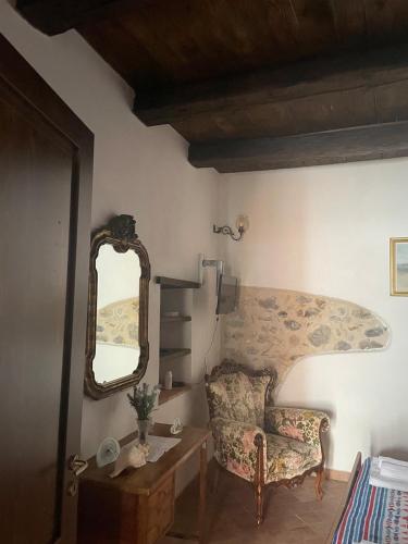 a living room with a chair and a mirror at La Casa di Mariannina in Monasterace
