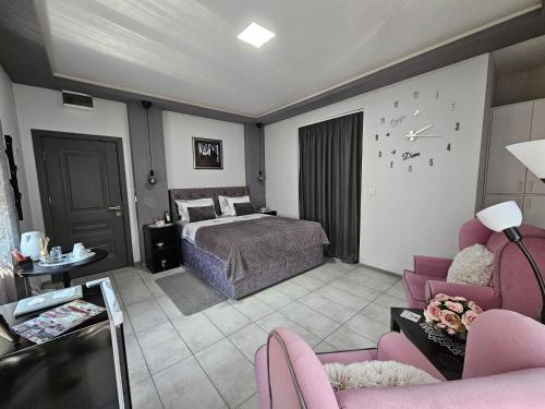 a bedroom with a bed and a couch and chairs at Apartmani i sobe Gromilovic in Sombor