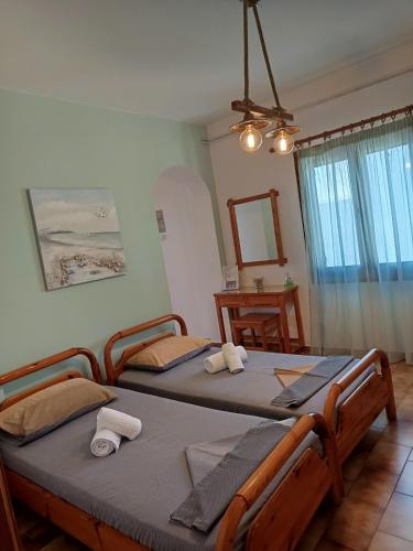 two twin beds in a room with a mirror at ANATOLI ROOMS SERIFOs in Serifos Chora