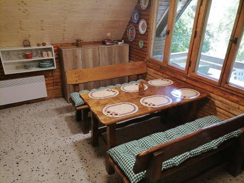 a dining room with a wooden table and chairs at Chata Roubenka in Jedovnice