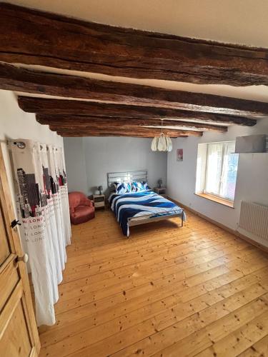 a bedroom with a bed and a wooden floor at Le gite de Francesco in Chemaudin