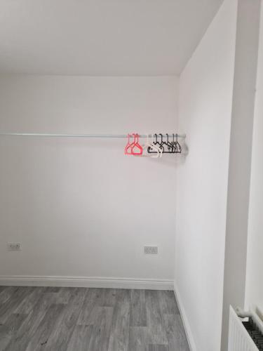 a white wall with a shelf with scissors on it at Nice flat near Silverstone in Buckingham