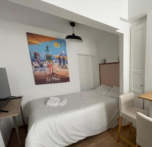 una camera da letto con un letto bianco e un quadro sulla parete di Stade Mayol a Tolone