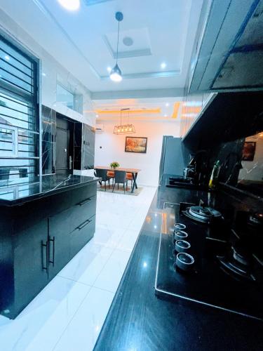 a kitchen with a stove and a living room at Ifemide Estates - Luxury Homes in Akure