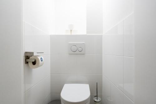 a white bathroom with a toilet and a window at Vienna Stay Apartments Schönbrunn in Vienna
